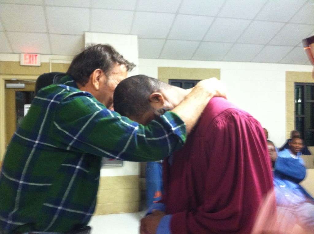 Dale Perkins prays with one of the men to accept Christ 